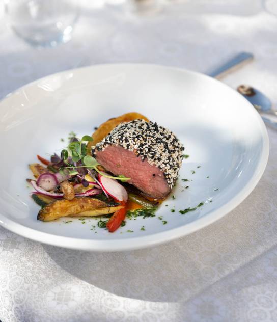 rosa gebratenes Fleisch auf Gemüse und Kartoffeln