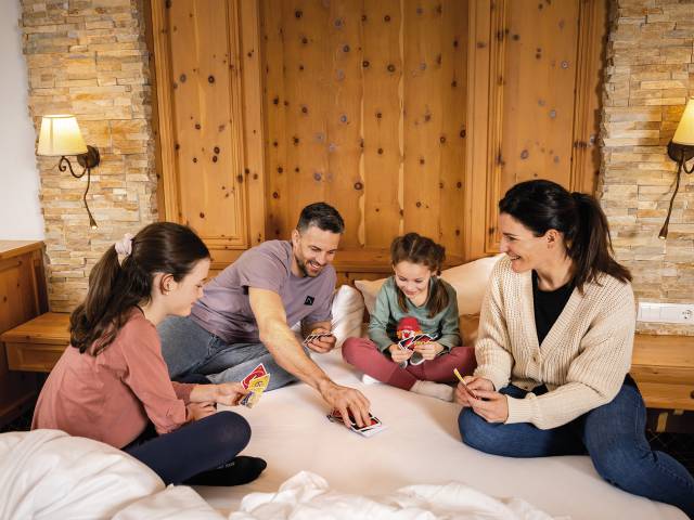 Familie spielt Karten im Familienzimmer