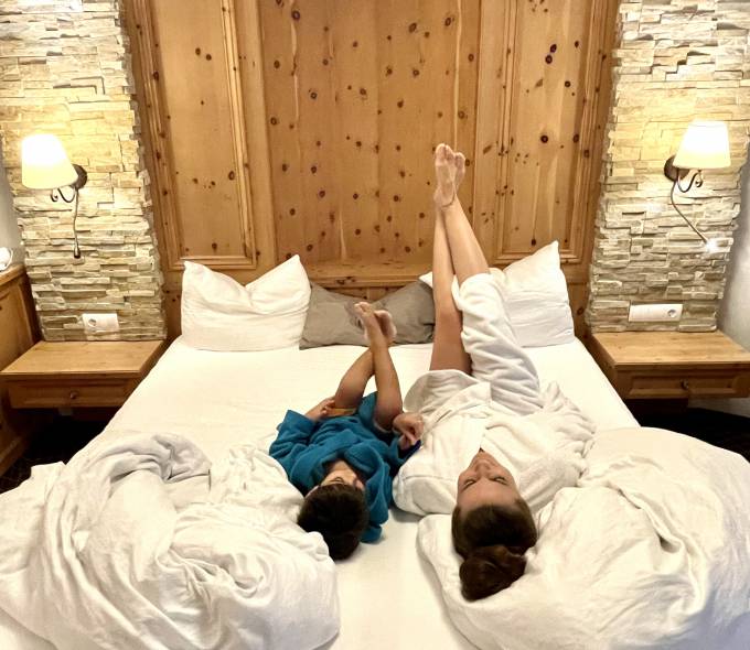 Mama und Kind im Bademantel auf dem Bett
