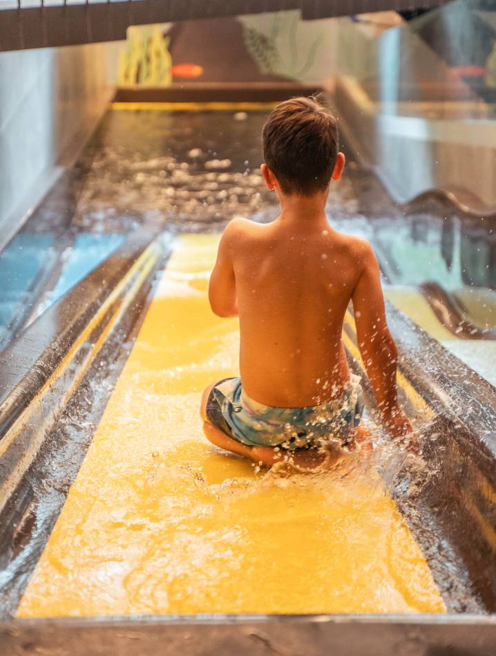 Kind auf der Kinderrutsche im Hotel Kindl