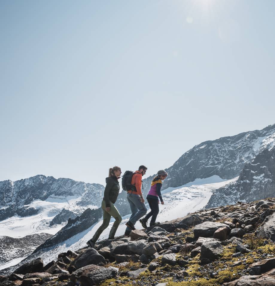 Familie wandert durch steiniges Gebiet am Stubaigletscher