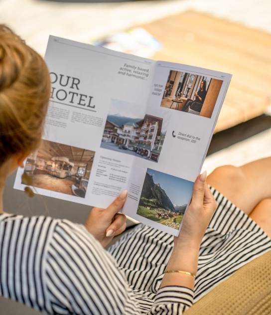 Frau liest Hotel Prospekt Hotel Kindl