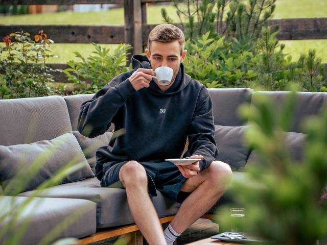 Mann trinkt Kaffee auf der Terrasse Hotel Kindl Ferienwohnung