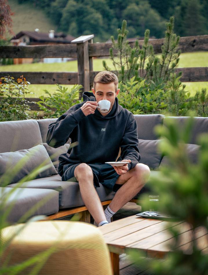 Mann trinkt Kaffee auf der Terrasse Hotel Kindl Ferienwohnung